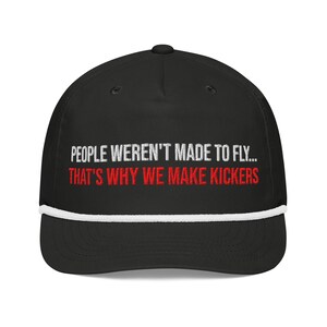 May include: Black baseball cap with a white brim and white stitching. The cap has the text "PEOPLE WEREN'T MADE TO FLY... THAT'S WHY WE MAKE KICKERS" embroidered in white and red.