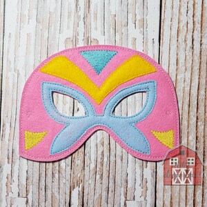 May include: Pink felt superhero mask with blue, yellow, and turquoise accents. The mask features eye cutouts and a decorative design. A fun accessory for costume play or themed events.