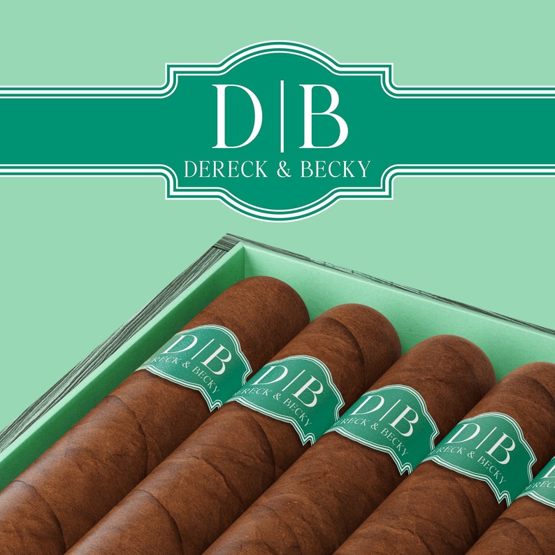 May include: A wooden box with four brown cigars inside. Each cigar has a green band with the text "DB Dereck & Becky" printed on it.