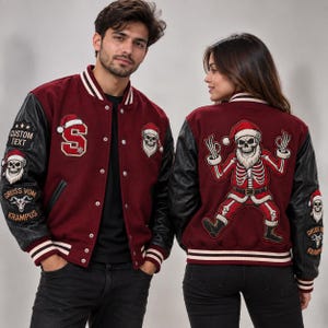 Könnte beinhalten: Eine bordeauxrote Collegejacke mit schwarzen Ärmeln, verziert mit Stickereien eines Skelett-Weihnachtsmanns, einem Buchstaben S mit Weihnachtsmütze sowie dem Text CUSTOM TEXT und GRUSS VOM KRAMPUS. Die Jacke hat gestreifte Rippbündchen und Druckknöpfe.