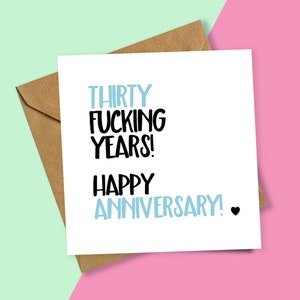 May include: A white card with the text "Thirty Fucking Years! Happy Anniversary!" in black and blue lettering. A small black heart is at the end of the text.