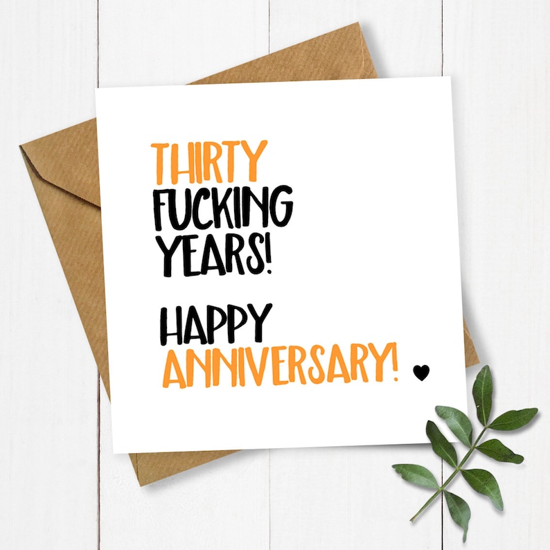 May include: A white card with black and orange text that reads "Thirty Fucking Years! Happy Anniversary!" with a small black heart.