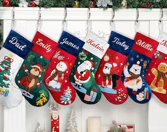 May include: Eight personalized Christmas stockings with embroidered names, including Dad, Emily, James, Kalvin, Tinley, Millie, and Mom. Each stocking features a different festive design with a snowman, Santa Claus, penguin, polar bear, reindeer, and gingerbread man.
