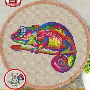 Könnte beinhalten: Ein gezähltes Kreuzstichmuster mit einem lebendigen Regenbogenchamäleon-Design. Das Muster wird in einem hölzernen Stickrahmen angezeigt, mit dem Text "COUNTED CROSS STITCH PATTERN FOR INSTANT DOWNLOAD #121 RAINBOW CHAMELEON". Das Design misst 23,5 x 17,8 cm.
