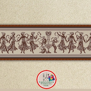 May include: A brown and white cross stitch pattern featuring a group of women dancing around a fountain. The pattern is framed in a brown wooden frame.