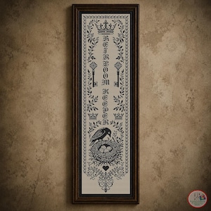 May include: A vertical framed cross-stitch sampler featuring black thread on a light fabric background. The design includes the text "HEIRLOOM KEEPER" vertically, flanked by keys, crowns, and floral vines, with a bird sitting on a nest at the bottom.