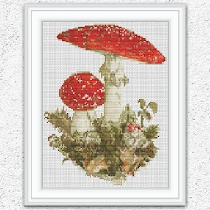 May include: Cross-stitch pattern of two red and white mushrooms with green foliage, framed in a white border. The image includes the text "Embroidery Patterns PDF" and "INSTANT DOWNLOAD PDF".