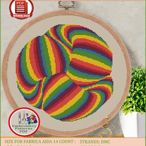 May include: A counted cross-stitch pattern for instant download, featuring an optical illusion design. The pattern is displayed in a wooden embroidery hoop, showcasing a colorful, swirling pattern in shades of red, orange, yellow, green, and blue. The design measures 8.2 x 8.4 inches.