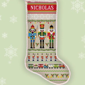 May include: A counted cross stitch pattern for a Christmas stocking featuring a Nutcracker theme. The stocking is beige with a red and white border and the name "NICHOLAS" at the top. The pattern includes three Nutcracker figures, a train, and other festive details.
