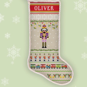 May include: A beige Christmas stocking with a red top, featuring the name "OLIVER" in white. The stocking is decorated with a nutcracker, toy soldiers, and a train. The words "COUNTED CROSS STITCH" and "INSTANT DOWNLOAD PDF" are also visible.