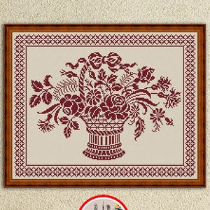 Puede incluir: Un patrón de punto de cruz enmarcado con un arreglo floral burdeos en una cesta. El diseño incluye rosas, hojas y otras flores, con un borde decorativo. La imagen incluye el texto "Embroidery Patterns PDF" y "INSTANT DOWNLOAD PDF".