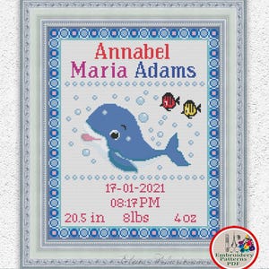 May include: Cross-stitch birth announcement for Annabel Maria Adams, featuring a blue whale, two small fish, and bubbles. The framed artwork includes the baby's birth date, time, length (20.5 inches), weight (8 lbs), and weight (4 oz).