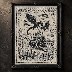 Può includere: Un ricamo a punto croce incorniciato con un'illustrazione a inchiostro nero su sfondo color crema. Il disegno raffigura un drago alato che vola sopra un castello e un cimitero con lapidi, circondato da un bordo floreale decorativo.