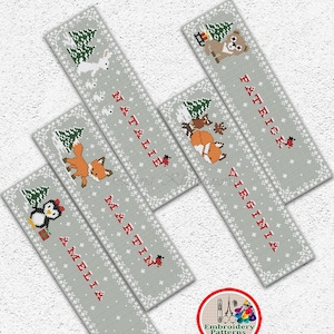 May include: Five gray and white cross-stitch bookmark patterns featuring winter scenes with animals and names. The names are:  "Natalie", "Martin", "Virginia", "Patrick", and "Amelia".