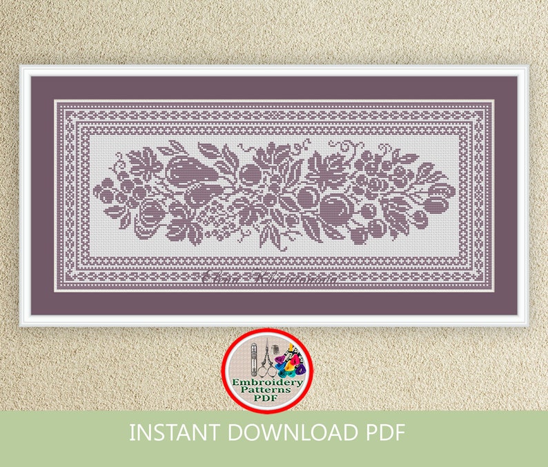 May include: A purple and white cross stitch embroidery pattern featuring a floral design with grapes, leaves, and fruit. The pattern is framed with a decorative border.
