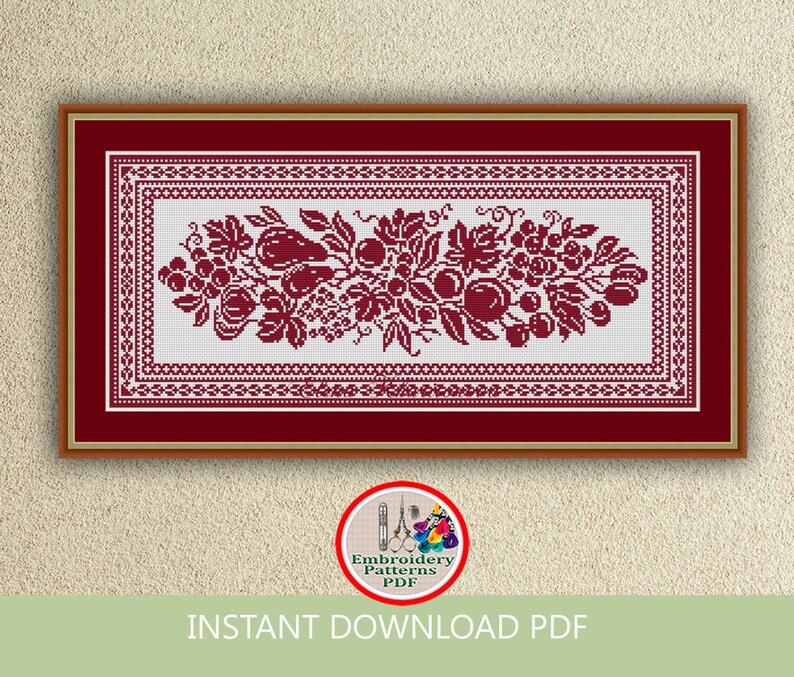 May include: A red and white cross stitch embroidery pattern featuring a floral design with grapes, leaves, and fruit. The pattern is framed in a red frame with a white mat.