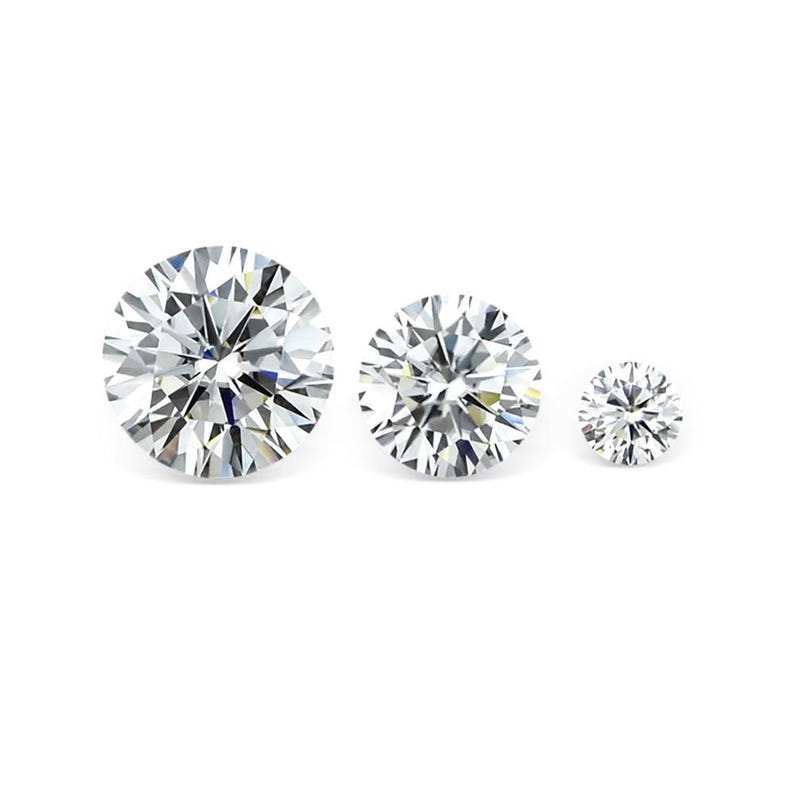 May include: Three round-cut, clear gemstones of varying sizes are displayed against a white background. The largest stone is in the front, followed by a medium-sized stone, and a smaller stone in the back. The facets of the stones reflect light, creating a sparkling effect.