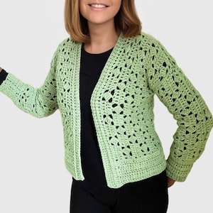 Peut inclure: Un cardigan en crochet vert clair avec un col en V et des manches longues.