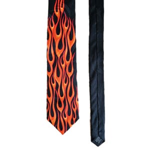 May include: Black necktie with a vibrant orange flame pattern. The flames are detailed and stylized against the black background. The tie is made of a smooth fabric and is suitable for formal or casual wear.