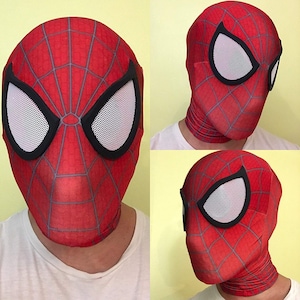 May include: A red Spider-Man mask with a web pattern and large white eye openings outlined in black. The mask covers the entire head and neck, with a close-up view of the face and two side views.