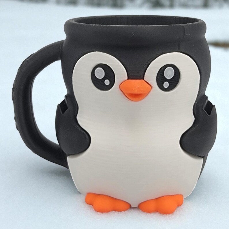 May include: A ceramic mug shaped like a penguin. The mug features a black rim, handle, and wings, with a white body and orange beak and feet. The penguin has large, round eyes.