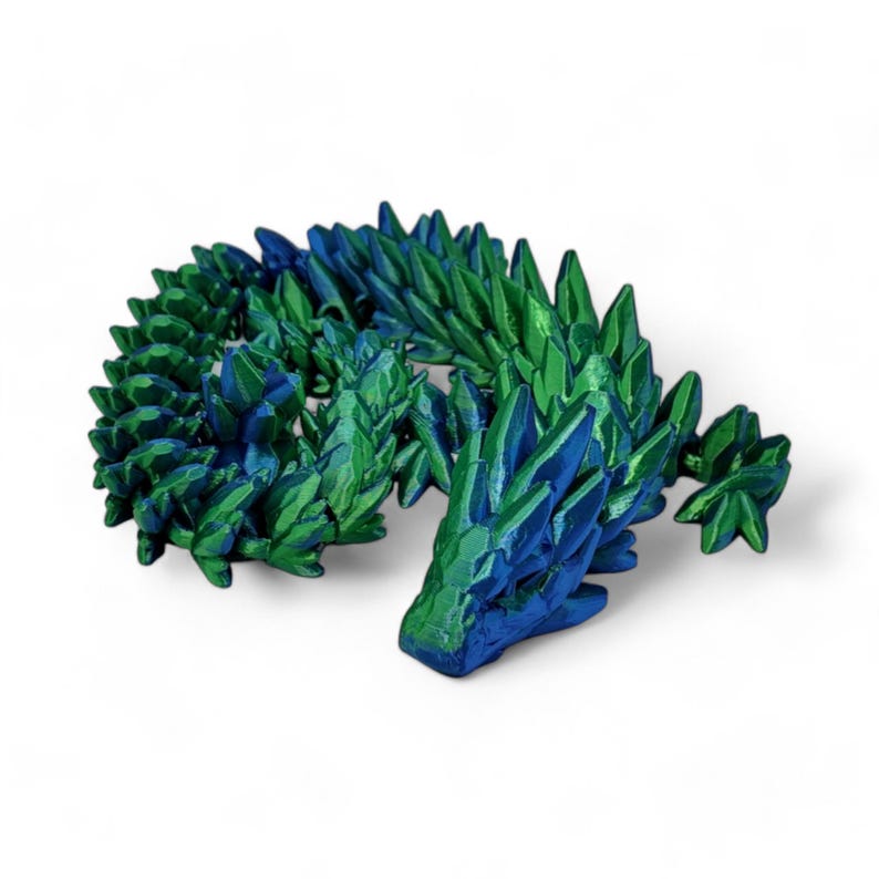 K&ouml;nnte beinhalten: Eine 3D-gedruckte Drachenfigur mit einem Farbverlauf von Blau zu Gr&uuml;n. Der Drache ist in einer schlafenden Position zusammengerollt, mit dem Kopf auf dem Schwanz.