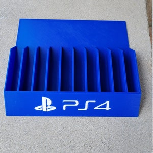 May include: A blue plastic game case with slots for storing PlayStation 4 game discs. The case has the PlayStation logo and the text "PS4" printed on the front.