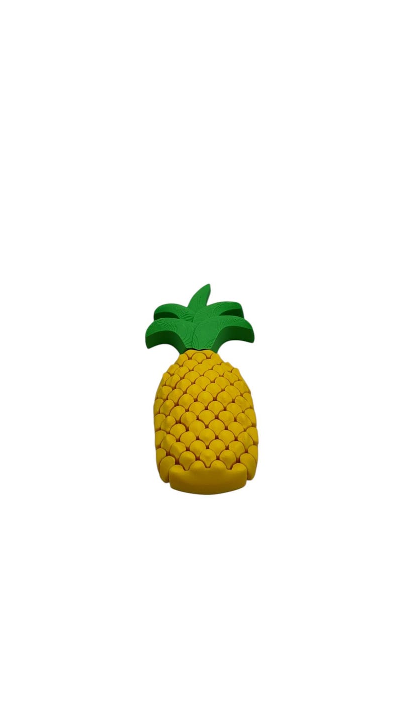 May include: A yellow pineapple-shaped object with a green leafy top. The pineapple has a textured surface, and the leaves are a vibrant green. The object is likely a decorative item or a toy.