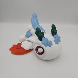 Pode incluir: Uma figura de criatura branca e caprichosa com um olho grande e redondo e detalhes coloridos. Apresenta detalhes azuis, verdes e vermelhos, com um corpo semelhante a uma nuvem e uma asa estilizada. O design &eacute; l&uacute;dico e imaginativo.
