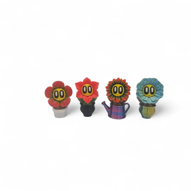 May include: Four whimsical flower-shaped figurines with smiling faces. The flowers are in various colors: red, orange, and blue. Each flower has a unique pot or watering can base. The background is plain white.