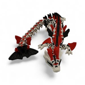 May include: A detailed, articulated dragon figurine in red, black, and white. The dragon has a segmented body, wings, and a detailed head. The color scheme includes red accents on the wings and spine, with black and white patterns throughout the body.