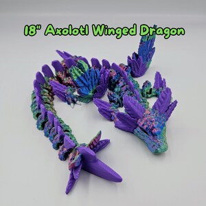 May include: An 18-inch purple and green axolotl winged dragon figurine. The dragon has a long, segmented body with wings and a head with a toothy grin.