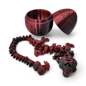 May include: A red wooden box with a mushroom design, open to reveal a string of small red mushroom-shaped beads.