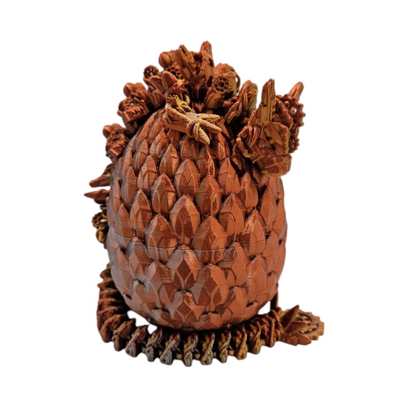 May include: A 3D printed dragon egg with a textured, scaly surface. The egg is a reddish-brown color and has a detailed, intricate design.
