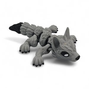 Peut inclure: Une figurine de renard articul&eacute;e grise avec une queue et des pattes noires. Le renard a un museau pointu, de grandes oreilles et des yeux noirs. La figurine est faite d'un mat&eacute;riau textur&eacute; et est pos&eacute;e en position rampante.