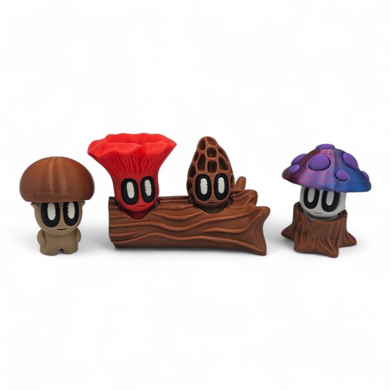 May include: A collection of whimsical mushroom figurines in various shapes and colors. The figurines include a brown mushroom, a red mushroom, a morel mushroom, and a purple and blue mushroom. The mushrooms have cartoon-like faces and are set against a white background.