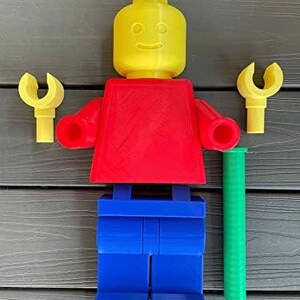 K&ouml;nnte beinhalten: Eine gro&szlig;e Lego-Figur in den Grundfarben: gelber Kopf, roter Torso und blaue Beine. Sie hat gelbe H&auml;nde und einen gr&uuml;nen Zylinder. Die Figur ist aus Kunststoff und als Spielzeug konzipiert.