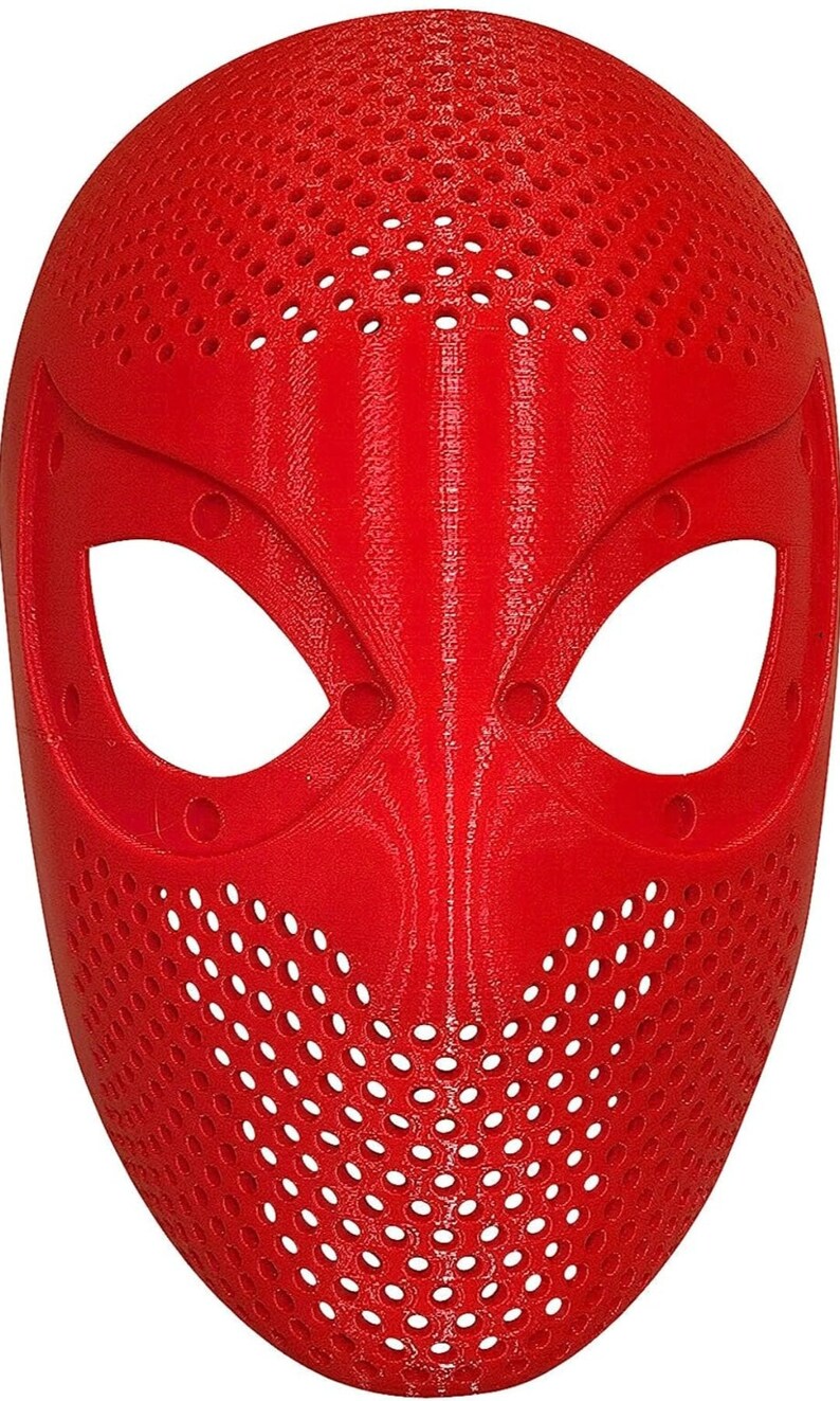 May include: A bright red mask with large eye openings and a perforated design across the forehead and mouth area. The mask has a smooth, curved surface and is likely made of plastic. The mask is a costume accessory.