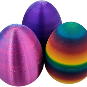 May include: Three Easter eggs, one purple, one pink, and one with a rainbow pattern.