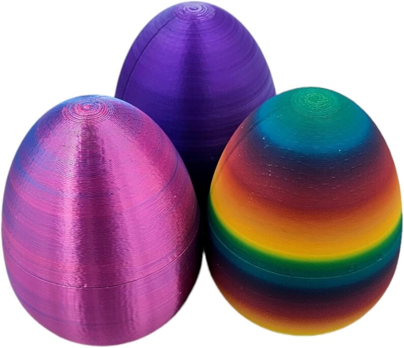 May include: Three Easter eggs, one purple, one pink, and one with a rainbow pattern.