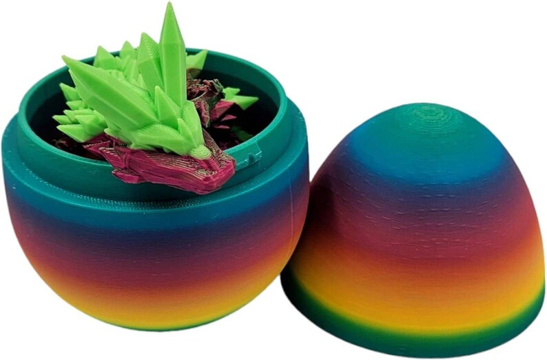 May include: A rainbow-coloured plastic egg opens to reveal a green and purple crystal dragon figurine inside.