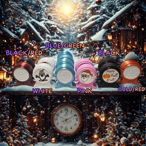 May include: A collection of decorative, barrel-shaped items in various colors, including black, red, white, blue, pink, and gold. Each item features a unique design or graphic, such as a gnome, Santa Claus, or a pumpkin with the text "Happy Fall Y'all!"