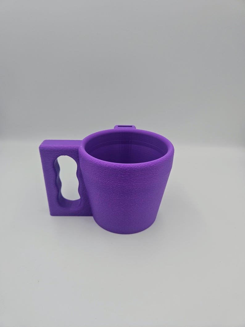 Pu&ograve; includere: Una tazza viola con una superficie strutturata e un manico. Il manico &egrave; rettangolare con un'apertura curva. La tazza &egrave; cilindrica con una forma leggermente affusolata. La tazza &egrave; realizzata in un materiale solido.