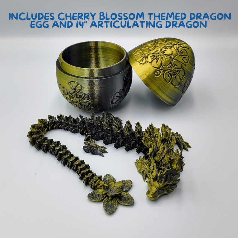 Pu&ograve; includere: Una statuetta di drago dorata con un design a fiore di ciliegio. Il drago &egrave; articolato e viene fornito in pezzi. Il drago &egrave; confezionato in un contenitore dorato a forma di uovo con un design a fiore di ciliegio. Il contenitore &egrave; aperto e il drago &egrave; parzialmente assemblato.  "INCLUDES CHERRY BLOSSOM THEMED DRAGON EGG AND 14" ARTICULATING DRAGON"