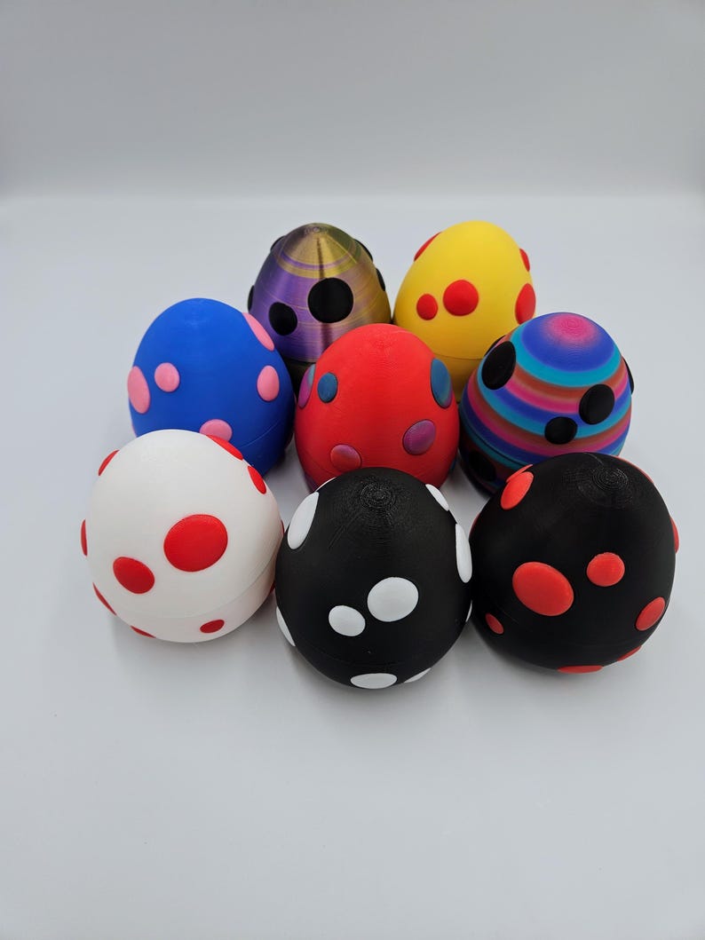 May include: Eight colorful speckled Easter eggs with different patterns and colors, including red, blue, white, black, yellow, and purple.