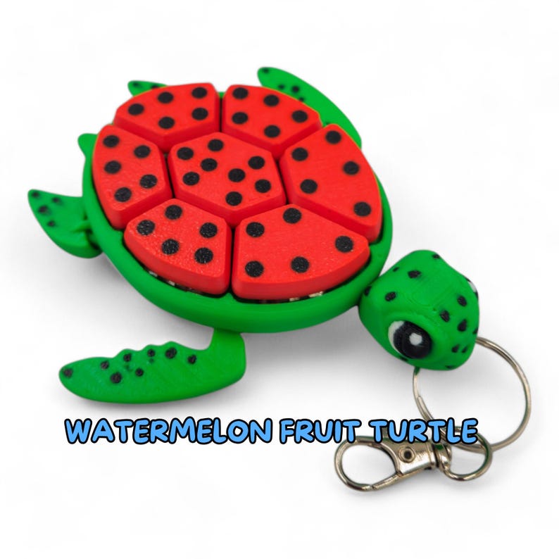 May include: A green and red watermelon fruit turtle keychain. The turtle's shell is made up of watermelon slices with black seeds. The turtle has a green head and feet.