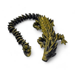 May include: A black and gold 3D printed figurine of a dragon with a long, segmented tail.