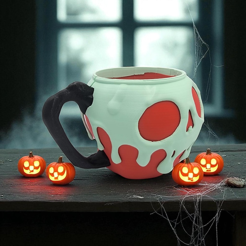 Pode incluir: Uma caneca com tema de Halloween com um design de caveira, exterior branco e detalhes vermelhos. A caneca tem uma al&ccedil;a preta e &eacute; cercada por pequenas decora&ccedil;&otilde;es de ab&oacute;bora laranja brilhantes. Uma teia de aranha adiciona uma atmosfera assustadora.