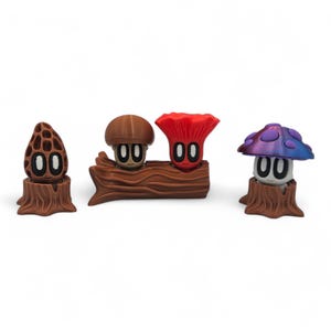 May include: Three whimsical mushroom figurines in brown, red, and purple hues. Each mushroom has a smiling face with the number "00" for eyes. One is on a tree stump, and two are on a log.