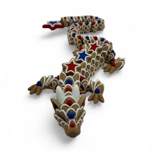 May include: A brown dragon figurine decorated with red, white, and blue star and dot accents. The dragon has a detailed head, body, and limbs, with a curled tail. The design is reminiscent of a patriotic theme.